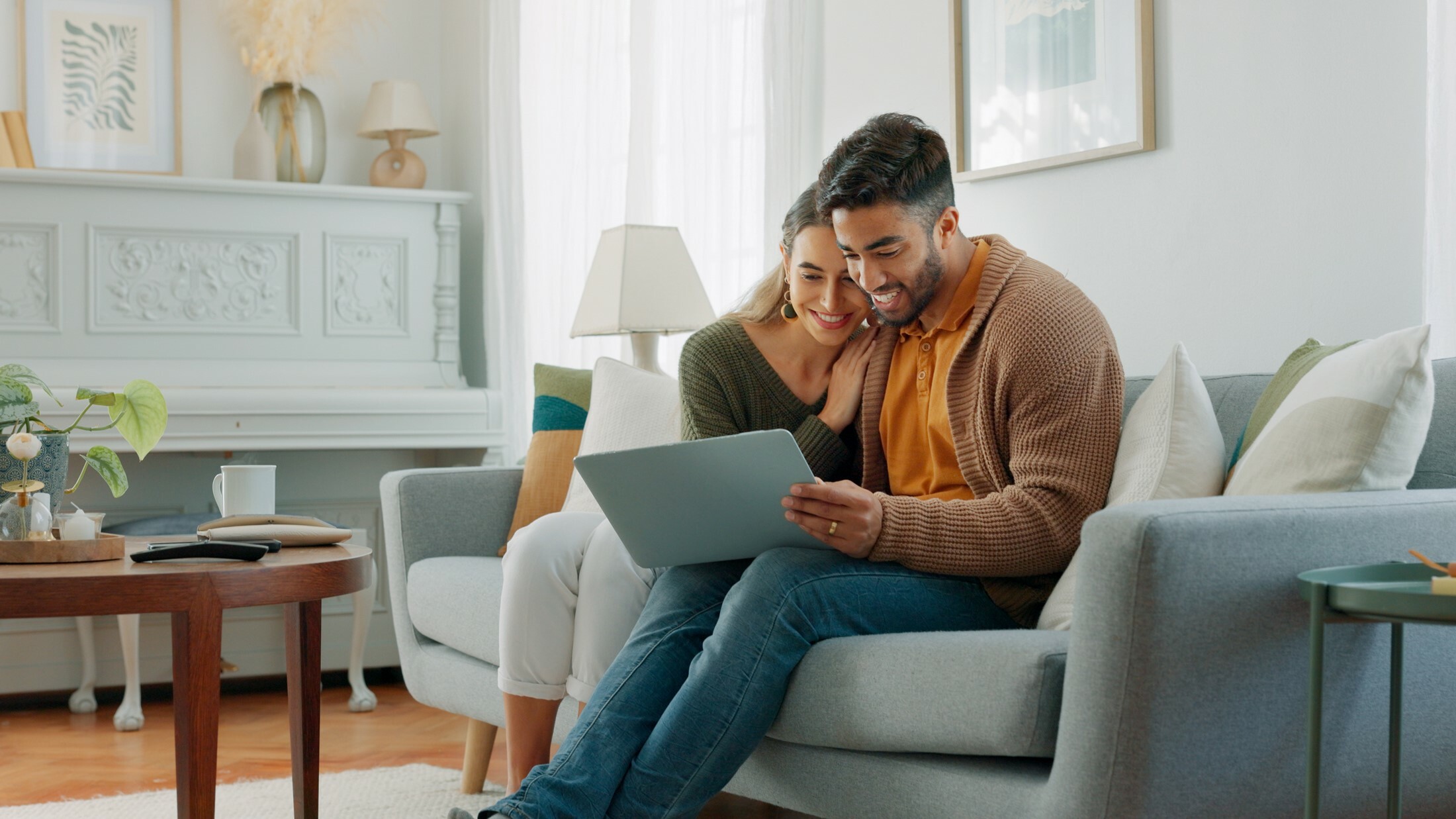 Couple on the couch looking at laptop